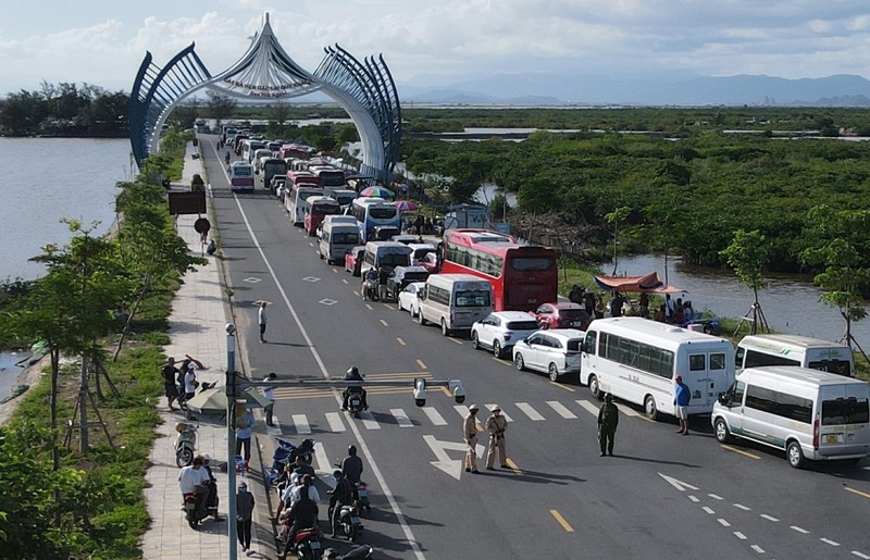 Ô tô chở khách du lịch tham quan đảo Cát Bà xếp hai hàng chạy dài hơn 1 km trên đường tỉnh 356 tại đầu bến Cái Viềng, chờ đến lượt xuống phà trở về đất liền. Ảnh : Báo Thanh Niên